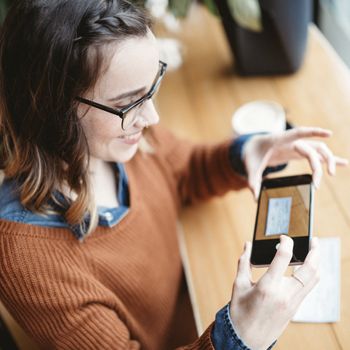 A woman uses Patelco Online to snap a photo of a check and make a mobile deposit with her phone.