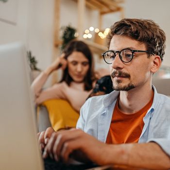 A man in glasses applies online for the Patelco Points Rewards Credit Card.