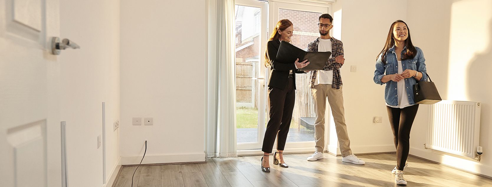 A couple tours a house with their real estate agent.