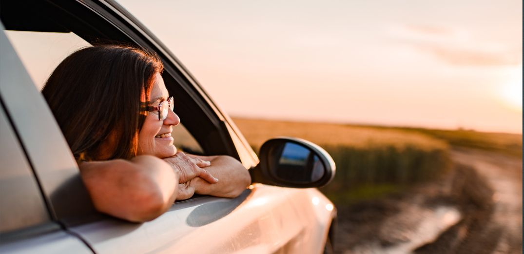 A Patelco member watches the sunset from her car window.