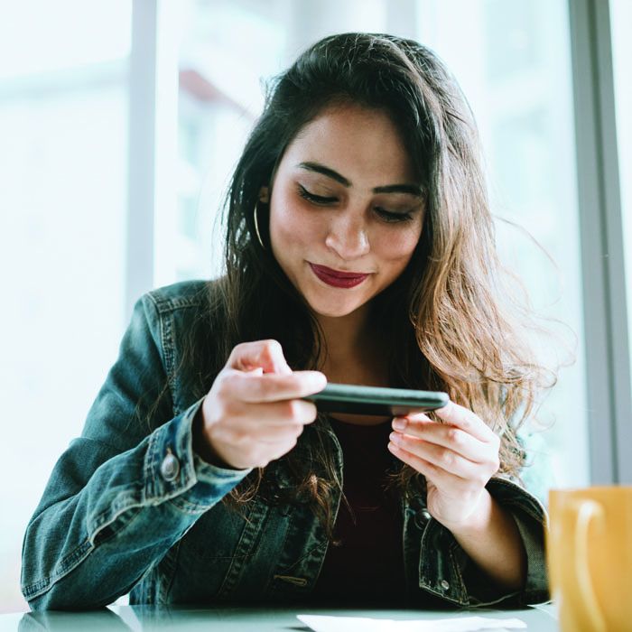 A woman snaps a photo of a check with the Patelco mobile banking app.