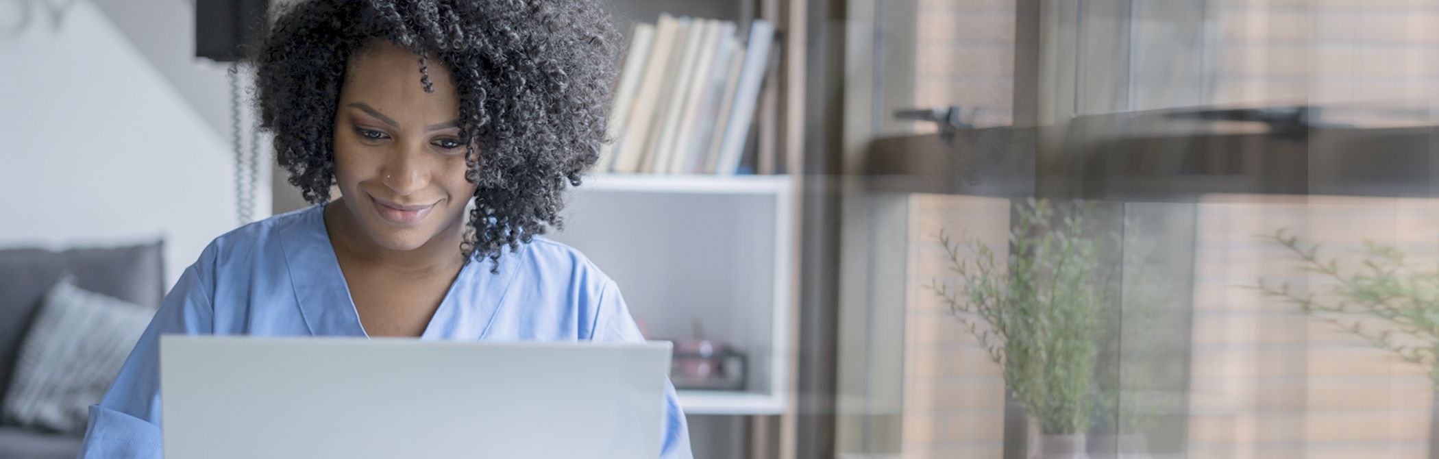 Someone indoors looking to schedule an appointment with their credit union on their computer