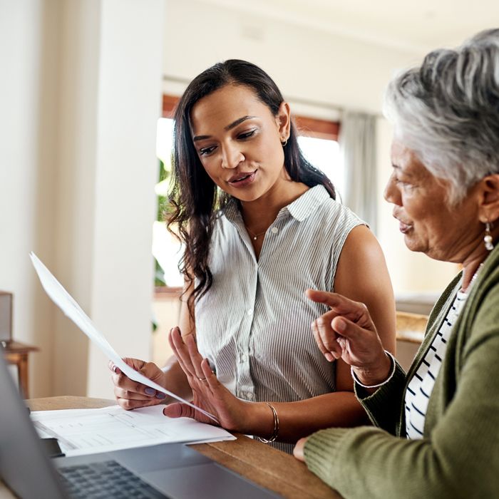 Mother and daughter at the dining table talking to each other about fraud prevention.